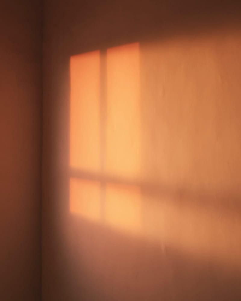 Low sun printing a window onto a warm wall
